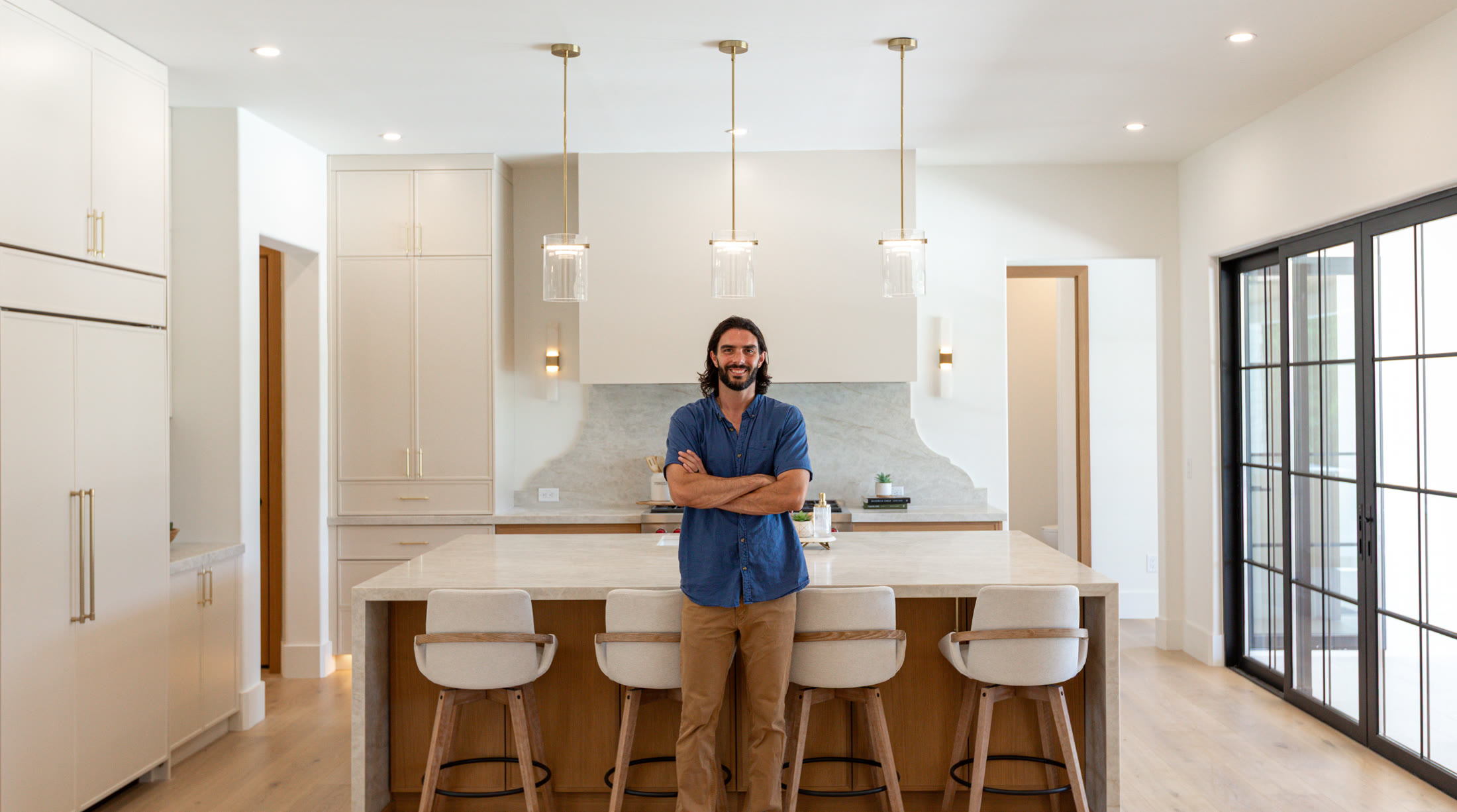 Michael Kopanski, Founder of Kalos Construction Group, standing at a custom kitchen island