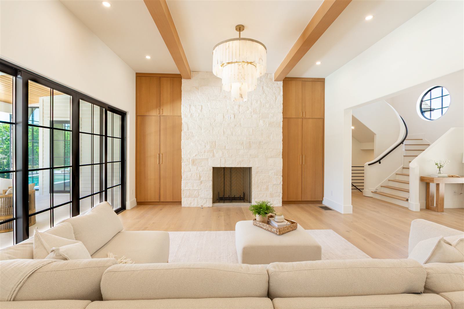 Great room with stone fireplace and curved staircase